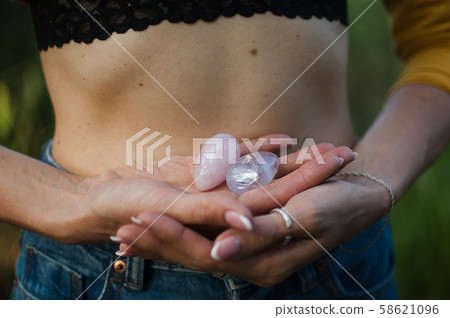 Female hands holding two yoni eggs for vumfit, imbuilding or meditation are made from pink quartz Female hands holding two yoni eggs for vumfit, imbuilding or meditation are made from pink quartz 58621096