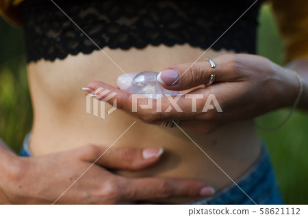 Female hands holding two yoni eggs for vumfit, imbuilding or meditation are made from pink quartz Female hands holding two yoni eggs for vumfit, imbuilding or meditation are made from pink quartz 58621112