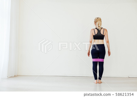 Female athlete squats with fitness gum sports Female athlete squats with fitness gum sports 58621354