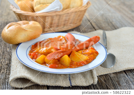 Hot potato goulash with Debreziner sausages and fresh rolls 58622322