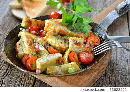 Fried Swabian meat ravioli (so called 'Maultaschen') with bacon and roasted cherry tomatoes Fried Swabian meat ravioli (so called 'Maultaschen') with bacon and roasted cherry tomatoes 58622331