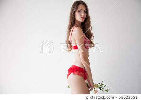 beautiful woman in red underwear with a flower on a white background beautiful woman in red underwear with a flower on a white background 58622551