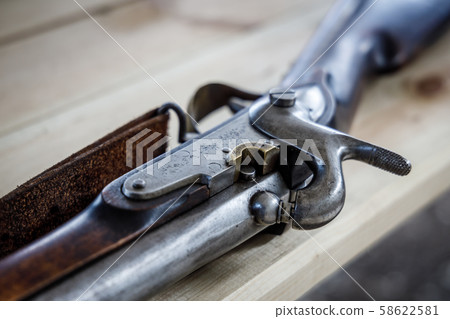 Antique flintlock gun lies on a wooden table Antique flintlock gun lies on a wooden table 58622581