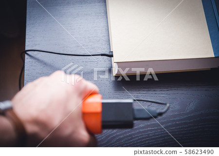 E-book and book connected with cable. White 58623490