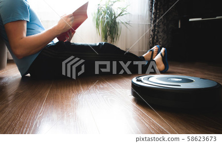 Robotic vacuum cleaner cleaning the room while 58623673