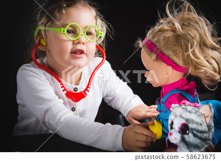 Cheerful little girl playing with her fluffy toy Cheerful little girl playing with her fluffy toy 58623675