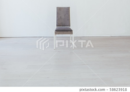 one gray chair in the interior of an empty white room one gray chair in the interior of an empty white room 58623918
