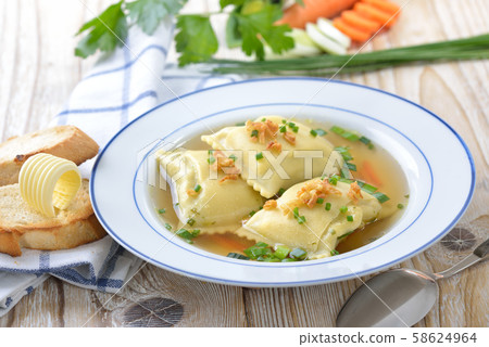 Vegetable broth with Swabian-style stuffed ravioli (so called 'Maultaschen') served with toast 58624964