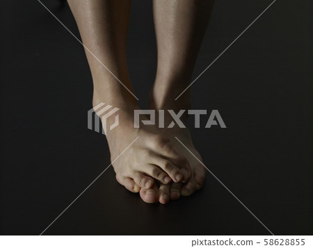 Lonely female bare feet black background Lonely female bare feet black background 58628855