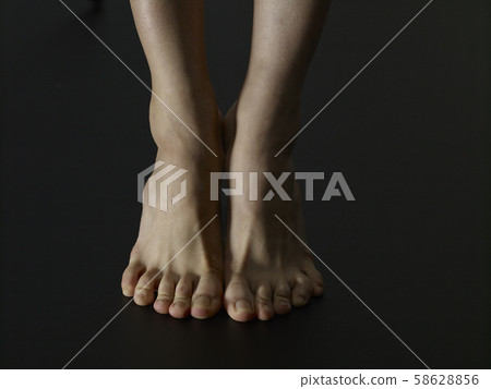 Lonely female bare feet black background Lonely female bare feet black background 58628856