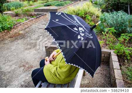 Seniors taking a parasol on a bench Seniors taking a parasol on a bench 58629410