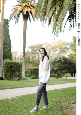 Chinese beautiful girl walking in tropical park. Chinese beautiful girl walking in tropical park. 58634761