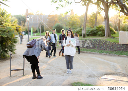 Photographer taking photo of chinese student with documents outside. 58634954