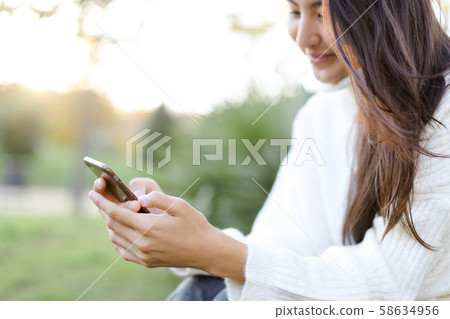 Focus on smartphone in chinese girl hands. Focus on smartphone in chinese girl hands. 58634956