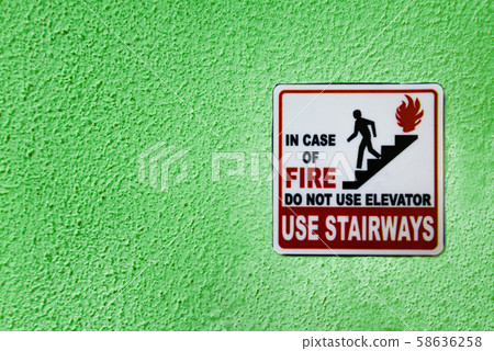 Warning sign on green wall with copy space 58636258