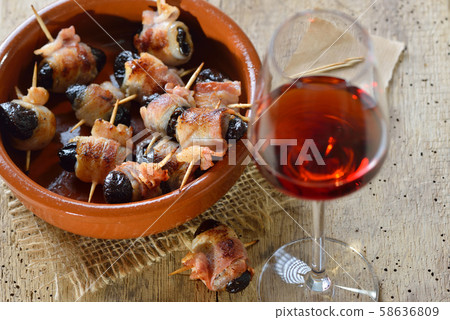 Delicious Spanish tapas: Fried prunes wrapped in bacon served with Portuguese port wine Delicious Spanish tapas: Fried prunes wrapped in bacon served with Portuguese port wine 58636809