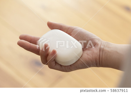 Hand of young woman with new soap Hand of young woman with new soap 58637911