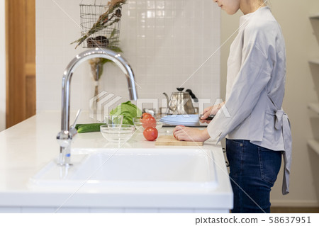 Hands of a young woman cutting vegetables in the kitchen 58637951