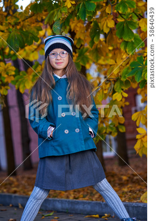 A teenager girl in glasses, a coat and a knitted A teenager girl in glasses, a coat and a knitted 58640439