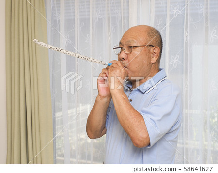 Senior man blowing blowback Senior man blowing blowback 58641627