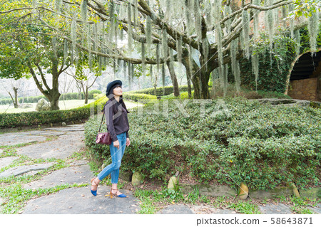 An Asian woman with a black hat is in the forest in Taichung, Taiwan. An Asian woman with a black hat is in the forest in Taichung, Taiwan. 58643871