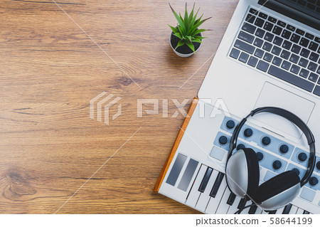 midi keyboard, headphone and laptop computer on wooden desk. music background, home studio concept 58644199