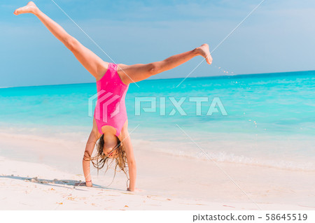 Adorable active little girl at beach during summer vacation 58645519