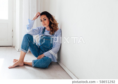 Portrait of a beautiful woman in a denim jumpsuit at home 58651292