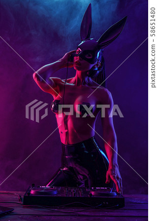Young sexy woman dj playing music. Headphones and dj mixer on table. 58651480