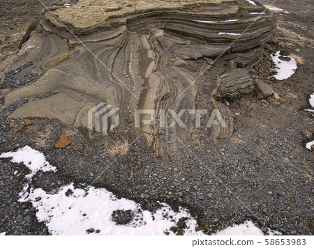 A rock formed by lava in Iceland with snow A rock formed by lava in Iceland with snow 58653983