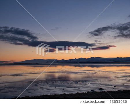Quiet sea in winter with sunset behind mountains Quiet sea in winter with sunset behind mountains 58653986