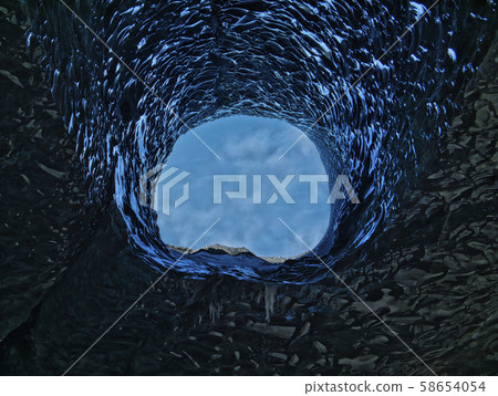 A large opening in a blue glacier cave 58654054
