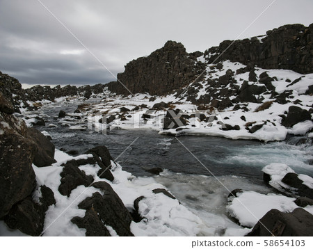 Rocky landscape around the Oexarfoss waterfall 58654103