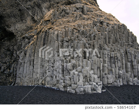 Rock face with basalt stones and black sand Rock face with basalt stones and black sand 58654107