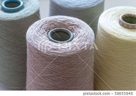 Pastel color bobbins of wool yarn for hand and machine knitting close-up Pastel color bobbins of wool yarn for hand and machine knitting close-up 58655848