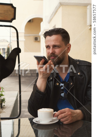 Trendy man on summer terrace cafe with smartphone Trendy man on summer terrace cafe with smartphone 58657577