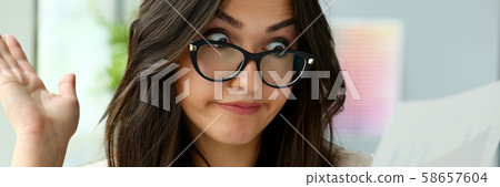 Young beautiful business woman holding glasses Young beautiful business woman holding glasses 58657604