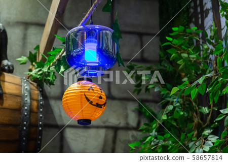 Pumpkins with lights decorated on trees at a Halloween party. 58657814