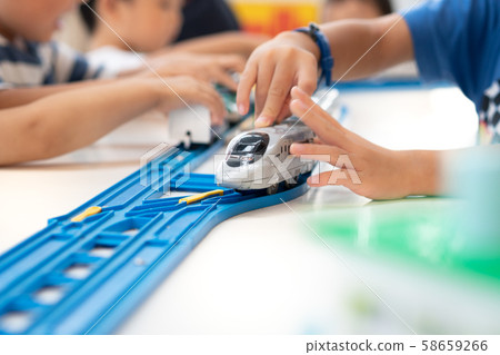 Close up of children hands playing, assembling the colorful plastic railway track. Educational hands-on toys, Kids Thinking skills, Creativity and imagination, Dexterity, Coordination, Gross motor. 58659266