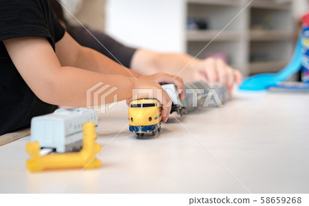 Close up of little children's hands playing, assembling the colorful plastic railway track. Educational hands-on toys, Kids Thinking skills, Social development, Japanese, Popular Model trains. Close up of little children's hands playing, assembling the colorful plastic railway track. Educational hands-on toys, Kids Thinking skills, Social development, Japanese, Popular Model trains. 58659268