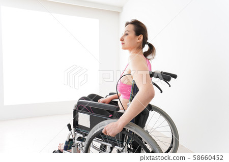 A foreign woman who wears sportswear and rides in a wheelchair 58660452
