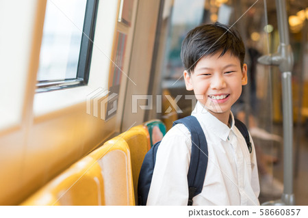 Happy, confident, smart looking preteen / teenage Asian boy carrying backpack , commuting to school in the morning in sky train on his own in city center. School and child development on independence. Happy, confident, smart looking preteen / teenage Asian boy carrying backpack , commuting to school in the morning in sky train on his own in city center. School and child development on independence. 58660857