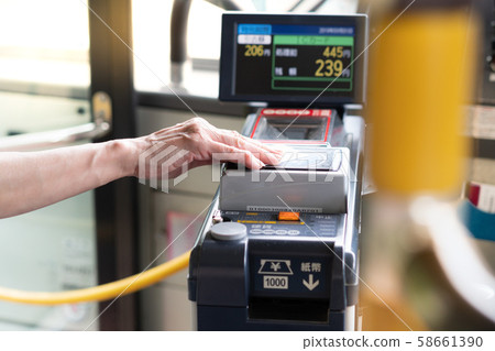 Japan, Tokyo - Sep 01 2019: Closeup of a eldery woman's hand waive a prepaid card on the contactless reader machine in a city bus. Public transportation, Japan's population ages, Senior discounts. 58661390