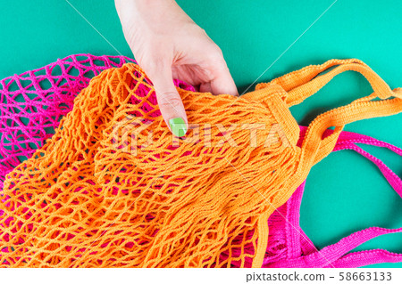 Zero waste. Color mesh shopping bags on green 58663133