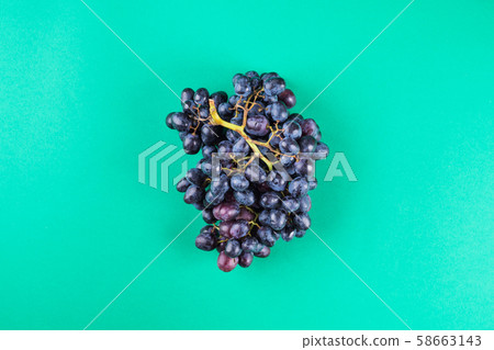 Dark grapes on green background 58663143
