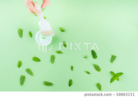 Hand with paint brush on green mint background Hand with paint brush on green mint background 58663151