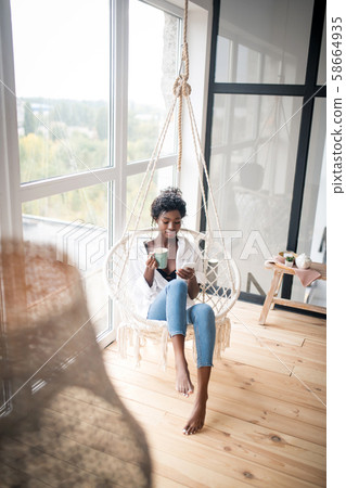 Top view of slim woman wearing jeans using phone and drinking coffee 58664935