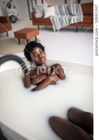 Dark-eyed young woman having amazing foamy bath Dark-eyed young woman having amazing foamy bath 58665347
