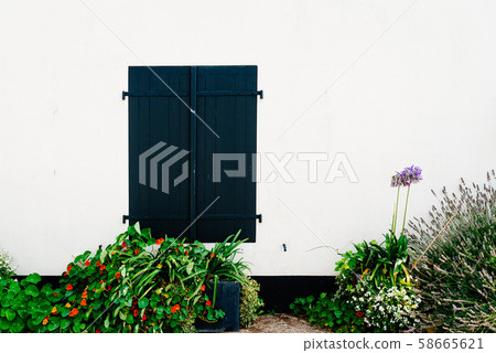 Old window with wooden light green painted shutters 58665621
