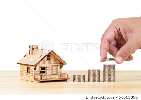 Coin stack and model house with hand putting money 58665866
